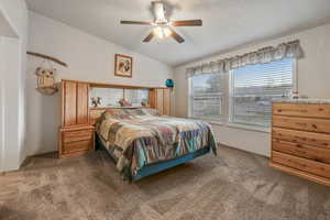 Bedroom featuring vaulted ceiling, carpet, and ceiling fan