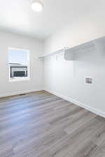 Walk in closet featuring wood finished floors and visible vents