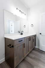 Bathroom with baseboards, wood finished floors, and vanity