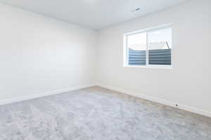 Carpeted empty room featuring visible vents and baseboards