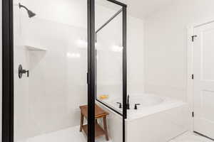 Full bathroom featuring a shower stall and a bath