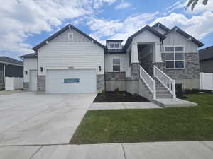 Craftsman-style home with stone siding, board and batten siding, and an attached garage