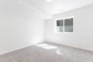 Spare room with baseboards, visible vents, and carpet floors