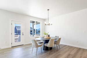 Dining area featuring a chandelier, light wood finished floors, and baseboards