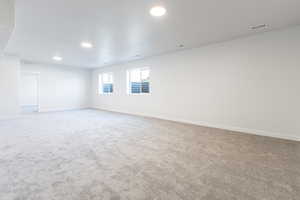 Spare room with recessed lighting, carpet floors, visible vents, and baseboards