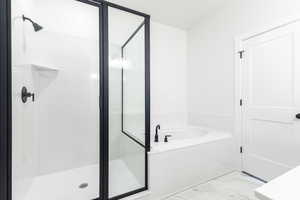 Bathroom featuring a garden tub, marble finish floor, and a shower stall
