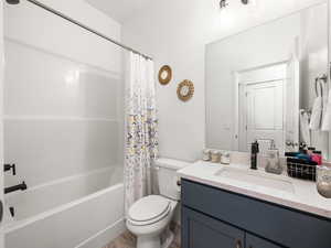 Full bath with shower / tub combo, toilet, and vanity