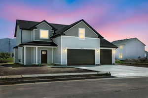 View of front of property featuring driveway, a garage, roof with shingles, and covered porch