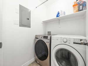 Clothes washing area with independent washer and dryer, electric panel, baseboards, and laundry area