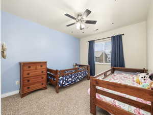 Bedroom featuring light colored carpet, baseboards, a ceiling fan, and visible vents