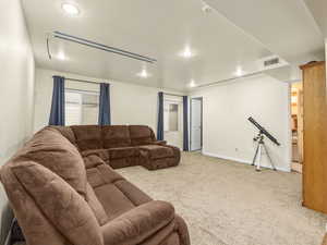 Carpeted living room with baseboards, visible vents, and recessed lighting, movie screen