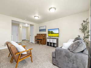 Living area featuring baseboards and light colored carpet