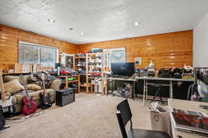 Home office with recessed lighting, wooden walls, a textured ceiling, and carpet flooring
