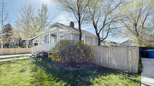 View of side of home featuring fence, a lawn, and a pergola