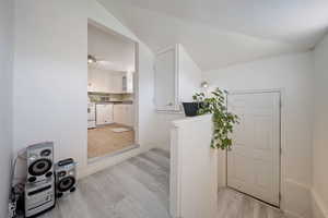 Bathroom featuring vaulted ceiling, wood finished floors, and baseboards
