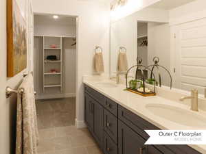 Full bath with a spacious closet, tile patterned flooring, a sink, and double vanity