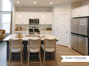 Kitchen with stainless steel appliances, light countertops, decorative backsplash, and recessed lighting