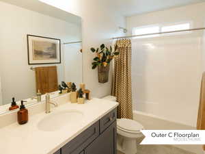 Full bathroom featuring tile patterned floors, toilet, vanity, and shower / bathtub combination with curtain