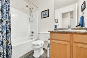 Full bath with tile patterned flooring, toilet, vanity, and shower / bathtub combination with curtain