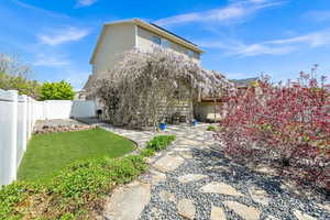Rear view of house featuring a gate, a yard, and a fenced backyard