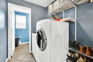 Clothes washing area featuring laundry area, baseboards, and washer and clothes dryer