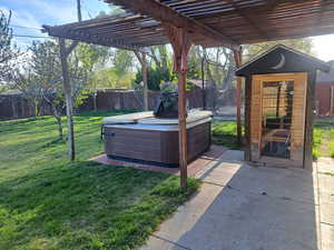 View of patio / terrace featuring a pergola, a trampoline, a hot tub, and a fenced backyard