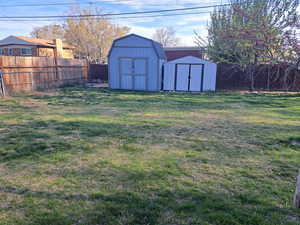 View of yard with a fenced backyard, an outdoor structure, and a shed