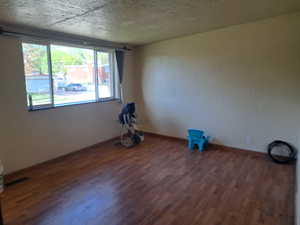 Spare room featuring visible vents, baseboards, and wood finished floors
