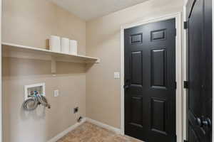 Clothes washing area with hookup for an electric dryer, washer hookup, laundry area, and baseboards
