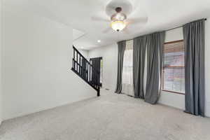 Carpeted empty room with a ceiling fan, baseboards, recessed lighting, and stairway