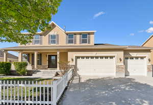 Traditional-style house with stucco siding, fence, and concrete driveway