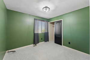 Unfurnished bedroom featuring baseboards, carpet flooring, visible vents, and a closet