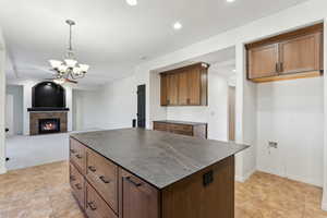 Kitchen featuring recessed lighting, dark countertops, hanging light fixtures, and ceiling fan with notable chandelier
