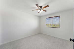 Empty room featuring visible vents, a ceiling fan, baseboards, and carpet flooring