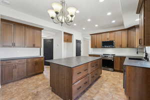 Kitchen with stainless steel appliances, a sink, recessed lighting, and dark countertops