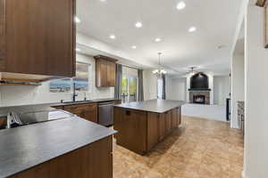 Kitchen featuring recessed lighting, a tile fireplace, stainless steel dishwasher, a center island, and open floor plan