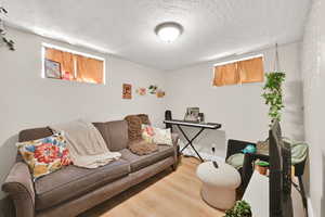 Living room with wood finished floors and a textured ceiling