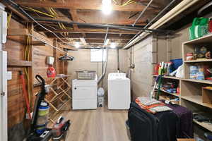 Unfinished below grade area featuring separate washer and dryer and wood finished floors