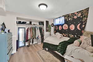 Bedroom featuring light wood-style floors, a closet, and baseboards