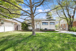 View of front facade featuring cooling unit, entry steps, a front yard, and fence