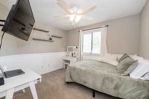 Bedroom with baseboards, a ceiling fan, and carpet