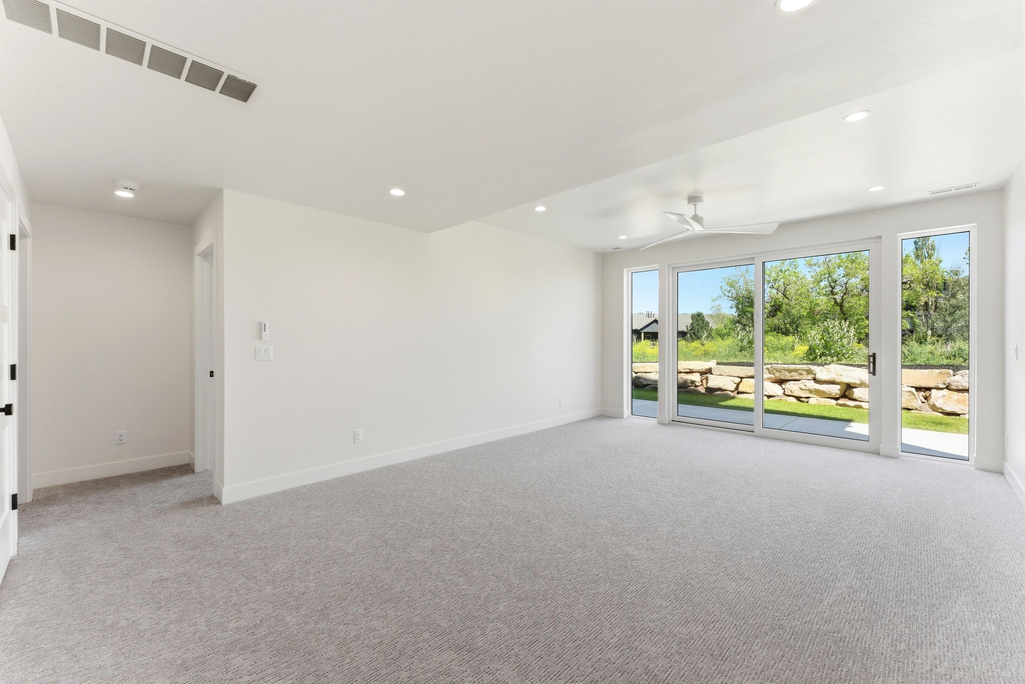 Bright interior space featuring light-toned carpeting and recessed lighting