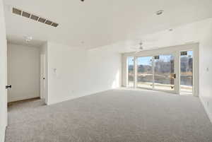 Unfurnished room with light carpet and a ceiling fan