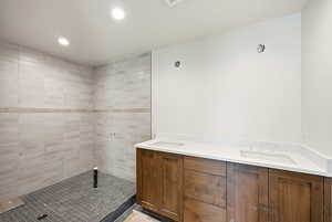 Bathroom featuring double vanity, recessed lighting, and a stall shower