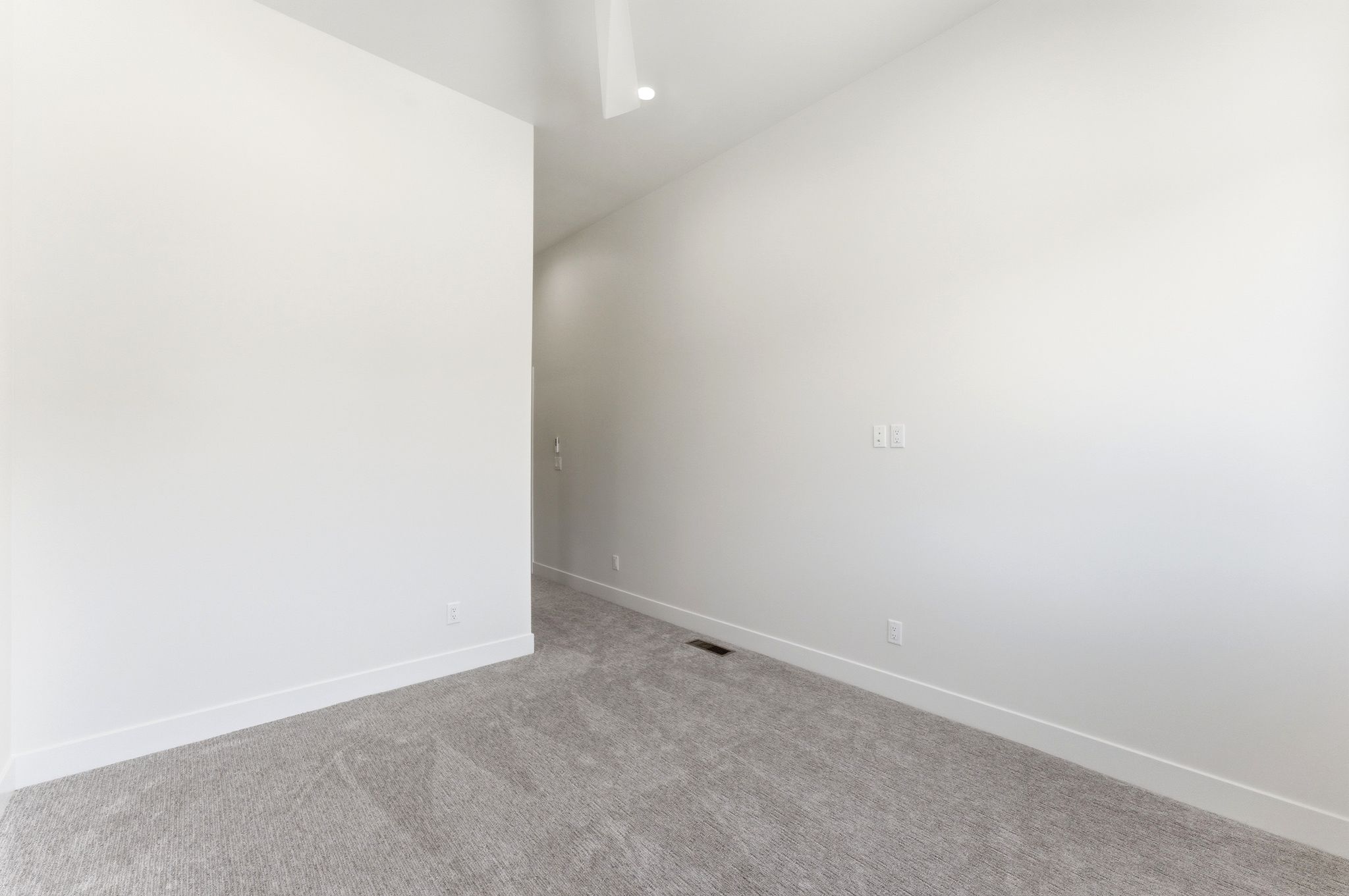 Carpeted room featuring light gray carpeting, white walls, white baseboards, and an overhead recessed light