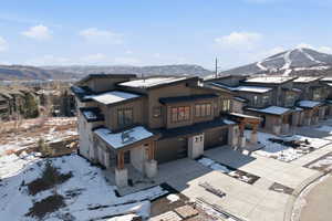 View of front of house featuring a garage, a residential view, a mountain view, and concrete driveway