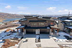 View of front facade featuring a garage, driveway, and a water and mountain view