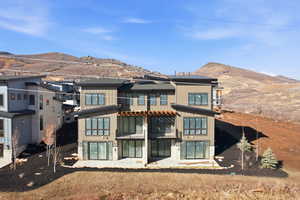 Rear view of property with a mountain view, a patio, and board and batten siding