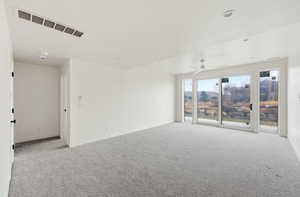 Unfurnished room featuring carpet flooring and a ceiling fan