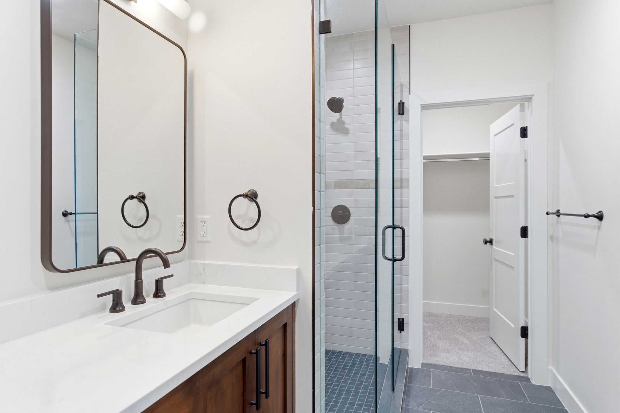 Modern bathroom featuring a wood-finish vanity with a white countertop and rectangular undermount sink